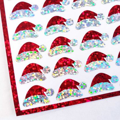 Mini Red Santa Claus Hats Sticker Sheet. Set of 78 Santa Hat decorative glitter stickers for ornaments, crafts, envelopes and gift bags