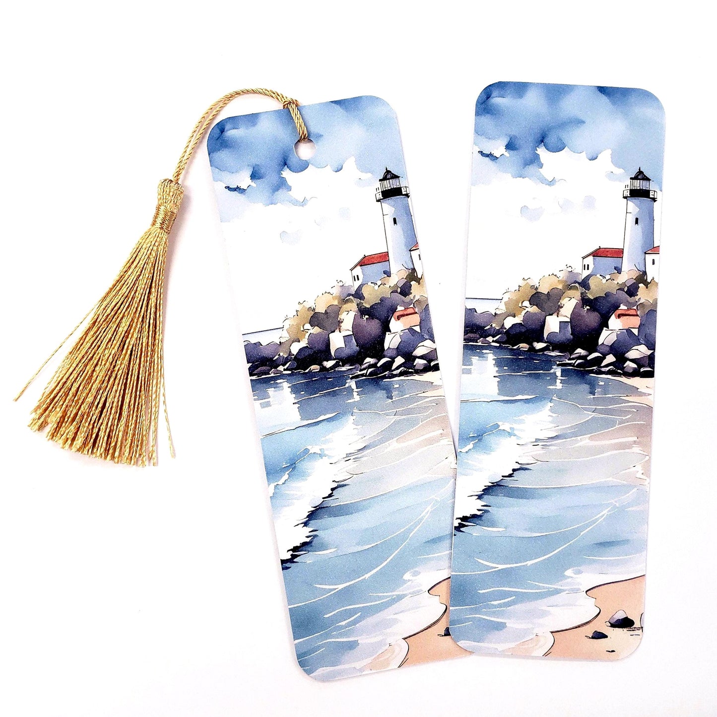 Two watercolor bookmarks with a lighthouse scene. The bookmarks are white with a blue and white watercolor scene of a lighthouse on a rocky shore with a blue ocean and white waves.