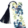 A white bookmark with a blue tassel. The bookmark features a watercolor illustration of blueberries on a branch with green leaves.