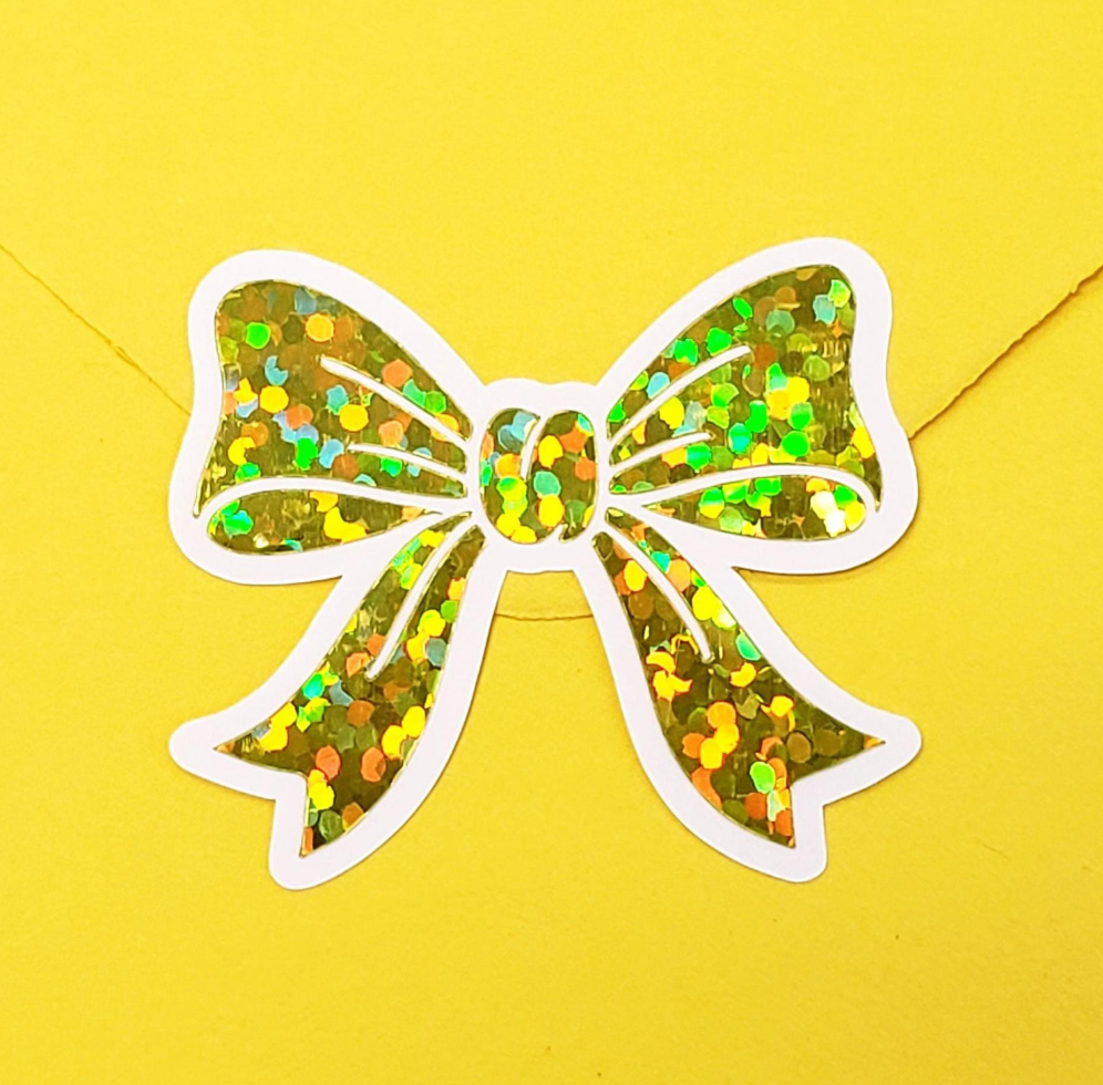 Set of 20 sparkly yellow bow stickers with a white outline.