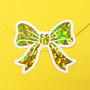 Set of 20 sparkly yellow bow stickers with a white outline.