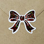 Brown bow stickers. Sheet of 20 individual peel and stick sparkly ribbon shaped decals with white outline.