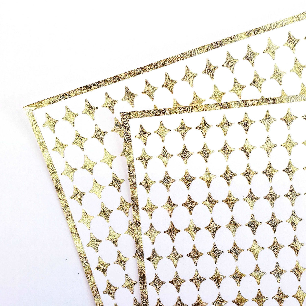 Small Gold Four-Pointed Stars Sticker Sheet. Set of 231 metallic gold peel and stick vinyl star decals for nails, planners and ornaments.