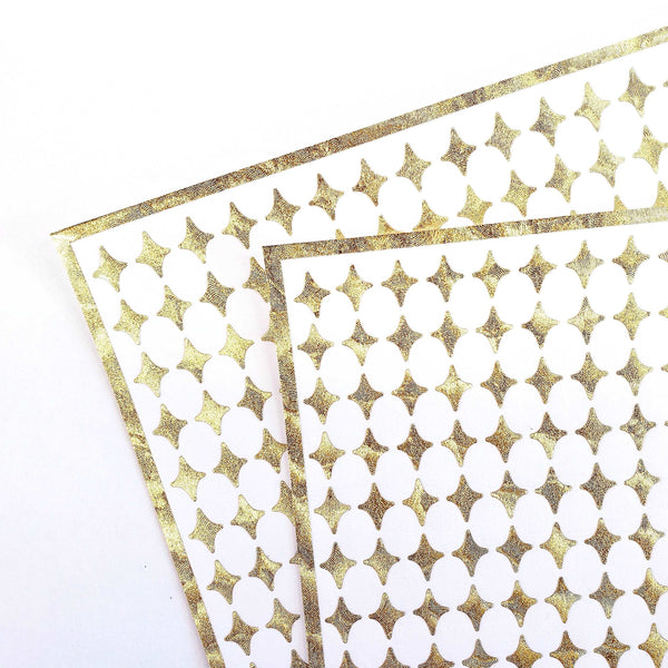Small Gold Four-Pointed Stars Sticker Sheet. Set of 231 metallic gold peel and stick vinyl star decals for nails, planners and ornaments.