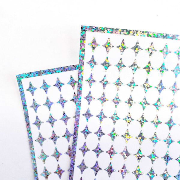 Small Silver Four-Pointed Stars Sticker Sheet. Set of 231 silver glitter peel and stick vinyl star decals for nails, planners and ornaments.