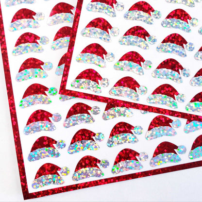 Mini Red Santa Claus Hats Sticker Sheet. Set of 78 Santa Hat decorative glitter stickers for ornaments, crafts, envelopes and gift bags