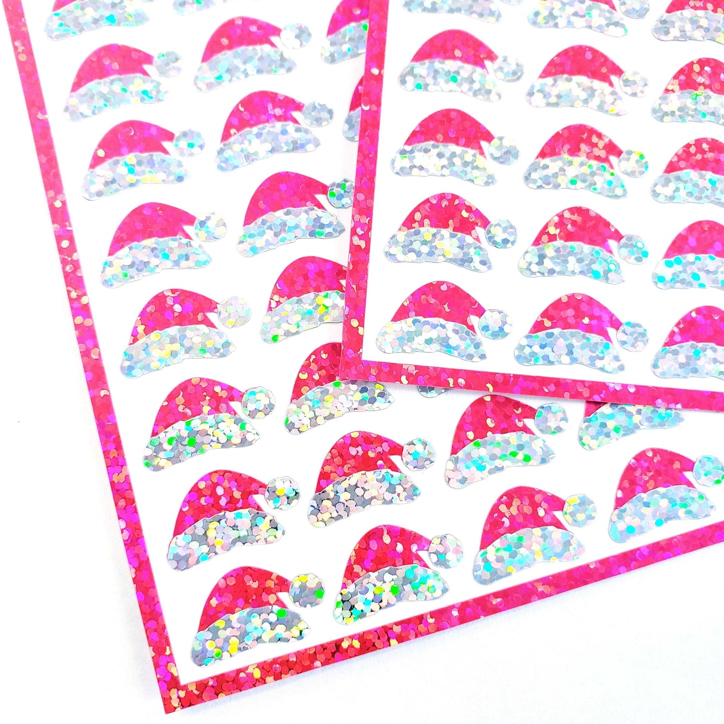 Mini Pink Santa Claus Hats Sticker Sheet. Set of 78 Santa Hat decorative glitter stickers for ornaments, crafts, envelopes and gift bags