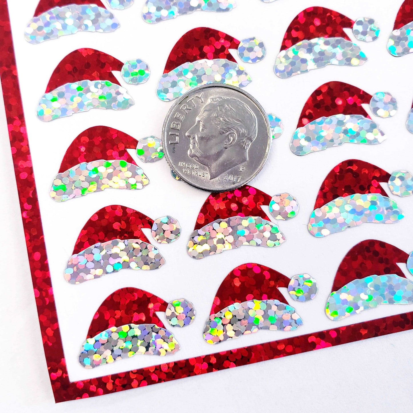 Mini Red Santa Claus Hats Sticker Sheet. Set of 78 Santa Hat decorative glitter stickers for ornaments, crafts, envelopes and gift bags