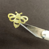 A gold bee sticker being with a craft knife.