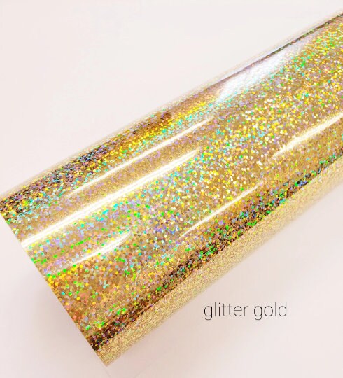 A roll of iridescent gold glitter vinyl with a fine, speckled texture. The vinyl is rolled up and the text "glitter gold" is visible at the bottom of the image.