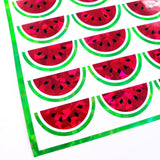 A sheet of holographic watermelon stickers. The stickers are red with black seeds and green outlines.