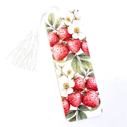 White bookmark with a tassel. The bookmark features a watercolor illustration of red strawberries and white flowers on green leaves.