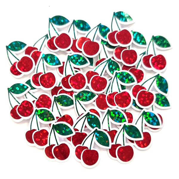 May include: A collection of red cherry-shaped sticker embellishments with clear outlines. The cherries have a glittery texture, and the leaves are green with a shimmering, iridescent effect. These decorative elements are scattered against a white background.