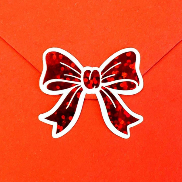 Sparkly red bow sticker sheet. Set of 20 peel and stick red bows with white outline.
