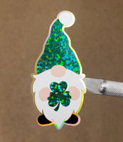 
              St. Patrick's Day Gnome Sticker, green and white gnome with shamrock, lucky gnome vinyl decal, sparkly glitter sticker for cards and laptops
            