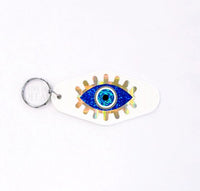 
              Retro Motel Style Keychain, white plastic key holder with sparkly blue and gold evil eye graphics, gift under 10 dollars
            