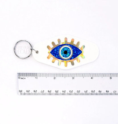 Retro Motel Style Keychain, white plastic key holder with sparkly blue and gold evil eye graphics, gift under 10 dollars
