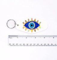 
              Evil Eye Keychain, retro motel style, black plastic key holder with sparkly blue eye graphics, gift under 10 dollars
            